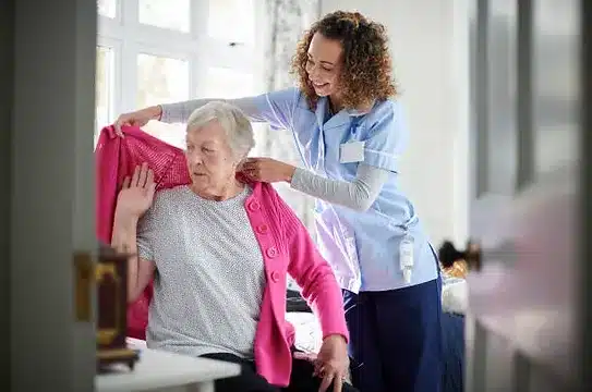 Elderly woman getting help dressing